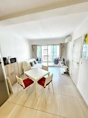 a kitchen and living room with a table and chairs at Appartement 2 pièces, emplacement de rêve Martinez in Cannes