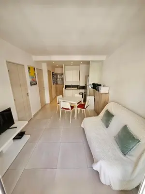 a room with a bed and a table and a kitchen at Appartement 2 pièces, emplacement de rêve Martinez in Cannes