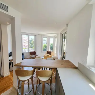 a kitchen and living room with a table and chairs at Appartement 3 pièces en plein coeur de Cannes in Cannes
