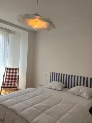 a bedroom with a large bed with a ceiling fan at Appartement 3 pièces en plein coeur de Cannes in Cannes