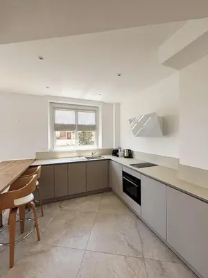 a white kitchen with a table and a sink at Appartement 3 pièces en plein coeur de Cannes in Cannes