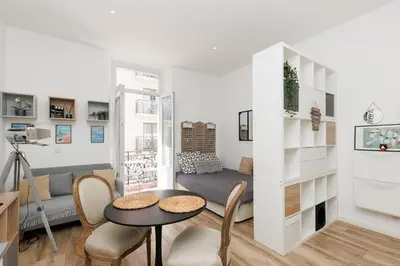a living room with a couch and a table and chairs at Le Hub Studio central climatisé avec terrasse in Cannes