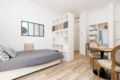 a bedroom with a bed and a dining room at Le Hub Studio central climatisé avec terrasse in Cannes