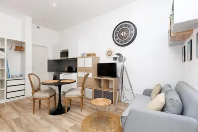 a living room with a couch and a table at Le Hub Studio central climatisé avec terrasse in Cannes