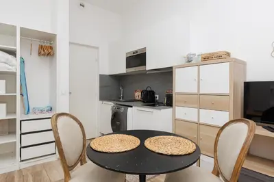 a kitchen with a table and chairs in a room at Le Hub Studio central climatisé avec terrasse in Cannes