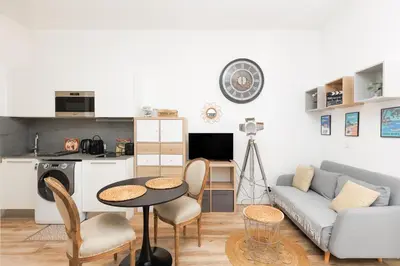 a living room with a couch and a table at Le Hub Studio central climatisé avec terrasse in Cannes