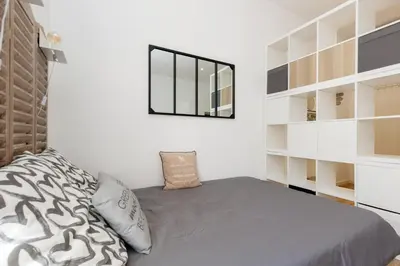 a bedroom with a bed and a mirror on the wall at Le Hub Studio central climatisé avec terrasse in Cannes