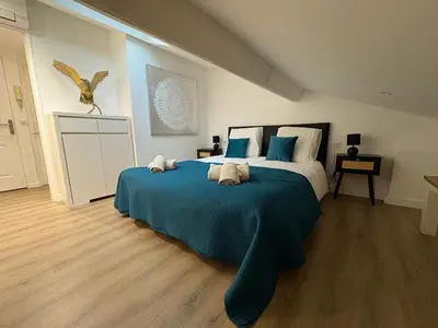 a bedroom with a large bed with blue sheets at Le Loft Cannes in Cannes
