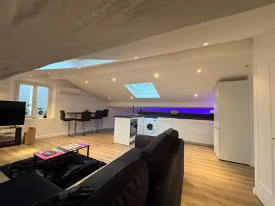 a living room with a couch and a kitchen at Le Loft Cannes in Cannes