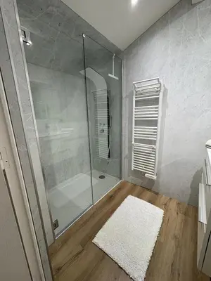 a bathroom with a glass shower and a white rug at Le Loft Cannes in Cannes