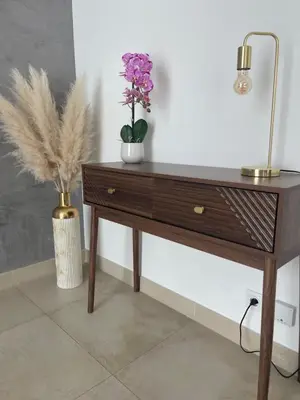 a wooden table with two flowers and a lamp on it at Apparemment cosy avec balcon plein centre de Cannes - Carla home in Cannes