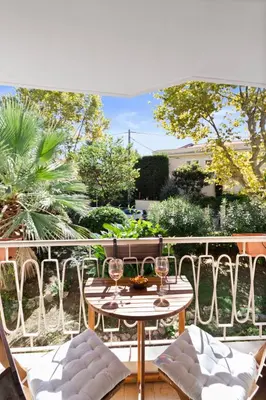 a patio with a table and chairs on a balcony at Le Tivoli - City Centre - Quiet - Spacious in Le Cannet