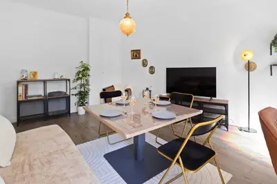 a living room with a wooden table and chairs at Le Tivoli - City Centre - Quiet - Spacious in Le Cannet