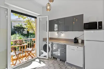 a kitchen with a sliding glass door leading to a patio at Le Tivoli - City Centre - Quiet - Spacious in Le Cannet