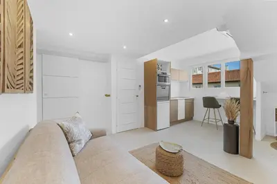 a living room with a couch and a kitchen at Studio V - à 2 min du Palais - Hypercentre - Calme in Cannes