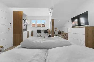 two beds in a white room with a kitchen at Studio V - à 2 min du Palais - Hypercentre - Calme in Cannes