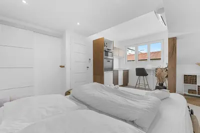 a white bedroom with a bed and a kitchen at Studio V - à 2 min du Palais - Hypercentre - Calme in Cannes