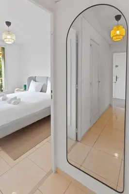 a mirror in a white room with a bed at Le Farniente - Peaceful - Parking - AC - Balcony in Le Cannet