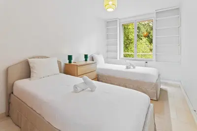 two beds in a room with a window at Le Farniente - Peaceful - Parking - AC - Balcony in Le Cannet