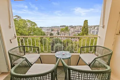 a balcony with two chairs and a table with a view at Le Farniente - Peaceful - Parking - AC - Balcony in Le Cannet