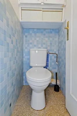 a white toilet in a blue tiled bathroom at Le Farniente - Peaceful - Parking - AC - Balcony in Le Cannet