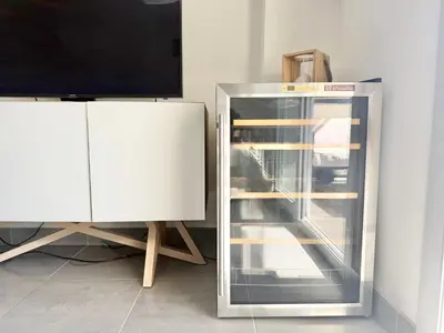 a refrigerator with its door open next to a tv at T2 - piscine - garage privé - 5 min de Cannes in Le Cannet