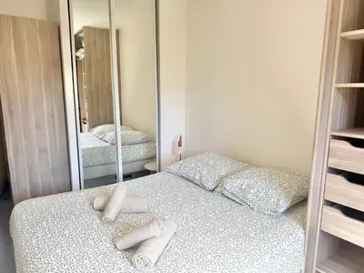 a bedroom with a bed and a large mirror at T2 - piscine - garage privé - 5 min de Cannes in Le Cannet