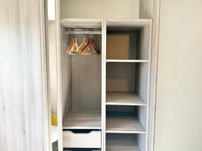 a white closet with wooden shelves at T2 - piscine - garage privé - 5 min de Cannes in Le Cannet