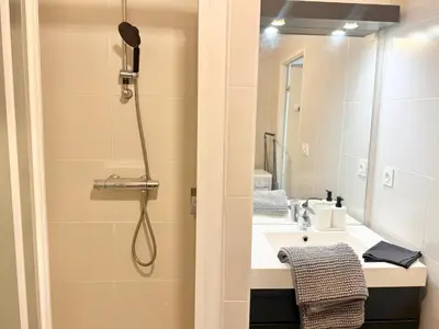 a bathroom with a shower and a sink and a mirror at T2 - piscine - garage privé - 5 min de Cannes in Le Cannet