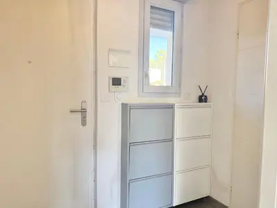 a white room with a window and a dresser at T2 - piscine - garage privé - 5 min de Cannes in Le Cannet