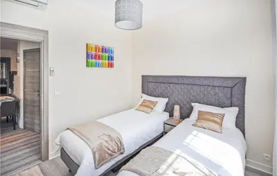 a bedroom with two beds and a mirror at 2 Bedroom Awesome Apartment In Cannes in Cannes