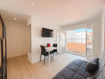 a living room with a couch and a table with chairs at 285G Studio 5mn Palais in Cannes