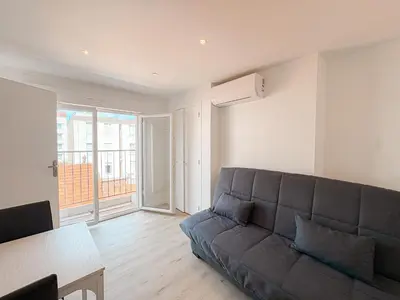 a living room with a couch and a table at 285G Studio 5mn Palais in Cannes