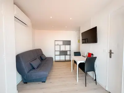 a living room with a couch and a table at 285G Studio 5mn Palais in Cannes