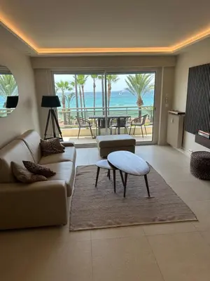 a living room with a couch and a table at Appartement Rottaro luxueux 2 ch 2 sdb face à la mer in Cannes
