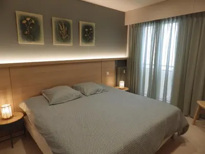 a bedroom with a bed with two pillows and a window at Appartement Rottaro luxueux 2 ch 2 sdb face à la mer in Cannes