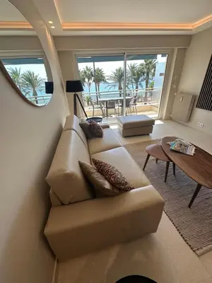 a living room with a couch and a table at Appartement Rottaro luxueux 2 ch 2 sdb face à la mer in Cannes