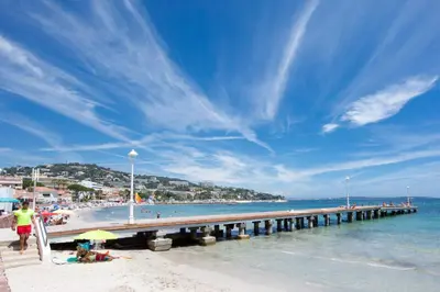 a pier on a beach with people on the beach at Apartment Seaside in Cannes