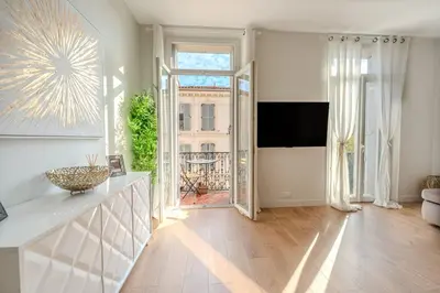 a living room with a large window and a television at Ideal Groupes & Familles 3 chambres - 10 pers - Hyper-centre Cannes in Cannes