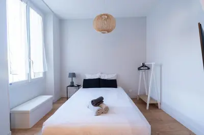 a bedroom with a white bed with a dog on it at Ideal Groupes & Familles 3 chambres - 10 pers - Hyper-centre Cannes in Cannes