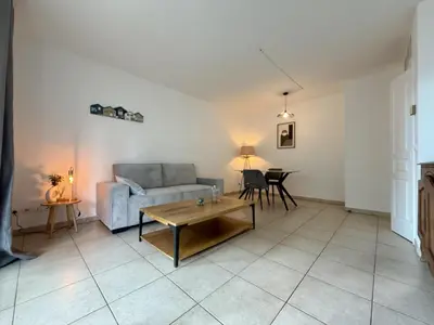 a living room with a couch and a table at DAPHNE, appartement piscine in Cannes