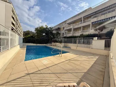 a swimming pool in front of a building at DAPHNE, appartement piscine in Cannes