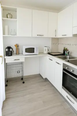 a white kitchen with white cabinets and a microwave at Étoile Riviera - Studio 2P, Centre, Plages & Palais in Cannes