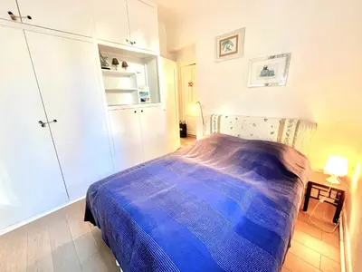 a bedroom with a bed with a blue blanket at La Marjolette by Welcome to Cannes in Cannes