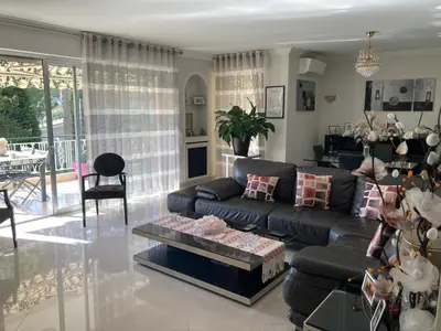 a living room with a leather couch and a table at Superbe appartement T3 à 2km centre Cannes in Le Cannet