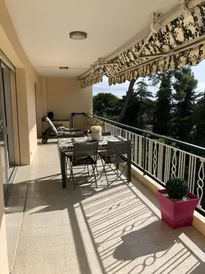 a patio with a table and chairs on a balcony at Superbe appartement T3 à 2km centre Cannes in Le Cannet