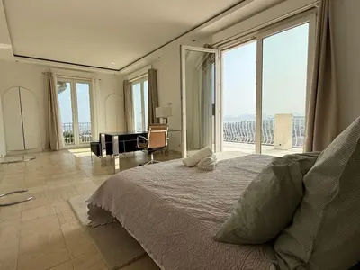 a bedroom with a bed and a large window at Grande villa, 6 chambres, vue mer, montagne & ville de Cannes in Le Cannet