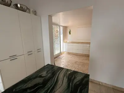 a kitchen with white cabinets and a large window at Grande villa, 6 chambres, vue mer, montagne & ville de Cannes in Le Cannet