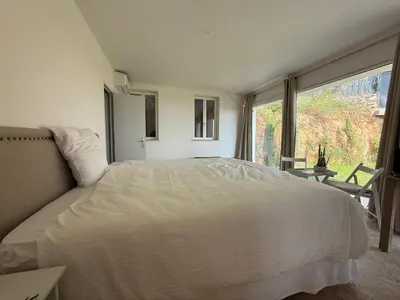a bedroom with a white bed and a large window at Grande villa, 6 chambres, vue mer, montagne & ville de Cannes in Le Cannet