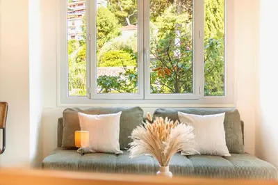 a couch in a living room with two windows at Apartment near Croisette and Cannes festival in Le Cannet
